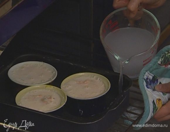 Наполнить формочки тестом с рыбой и поставить в глубокий противень, наполненный горячей водой.