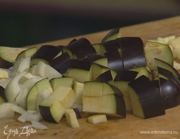 Разогреть в глубокой сковороде 1 ст. ложку оливкового масла и обжарить лук и чеснок, затем добавить баклажан, цукини и помидор. 
