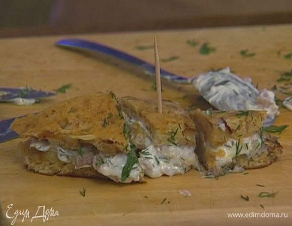 Нижнюю часть каждого треугольника присыпать укропом, смазать начинкой из селедки и сыра и накрыть верхней частью. Затем нарезать на еще меньшие кусочки и проткнуть коктейльными палочками.