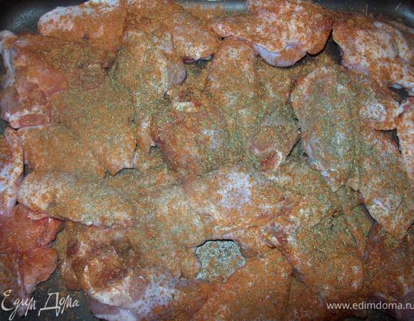 Кладем крылья в форму и обильно посыпаем красным перцем, сухими травами, солим.