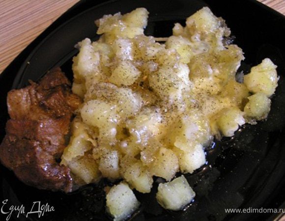 Обжарить картофель на оливковом масле до золотистой корочки, тушить 6 минут, пару раз встряхнуть сковородку, а за 2 минуты до готовности посыпать тертым сыром. Разложить по тарелкам, посыпать зеленью.