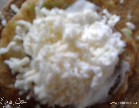 Отварить два яйца, натереть на мелкой терке. Майонез (у меня домашний) смешать с давленым чесноком и мелко нарубленым укропом. На мелкой терке также натереть плавленый сырок (или протереть творог). Берем оладушек и намазываем его майонезно-чесночной смесью, а сверху кладем чайную ложечку натертых яиц.