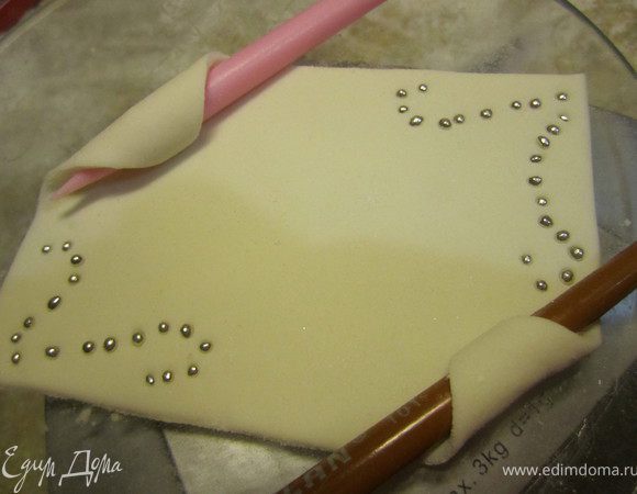 Заранее можно сделать такую табличку.
Просто раскатать кусочек мастики, вырезать нужную форму.
По углам можно сделать узор бусинками.
