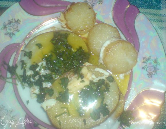 Как желток побелеет, выложить на тарелку, проколоть желток  и посыпать  зеленью