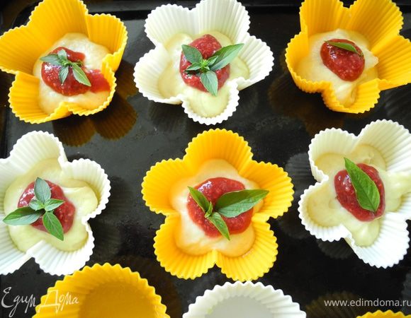 Формочки смазать маслом. Положить тесто в формы (примерно 1/3 формы), затем ложечку начинки и листочек базилика.