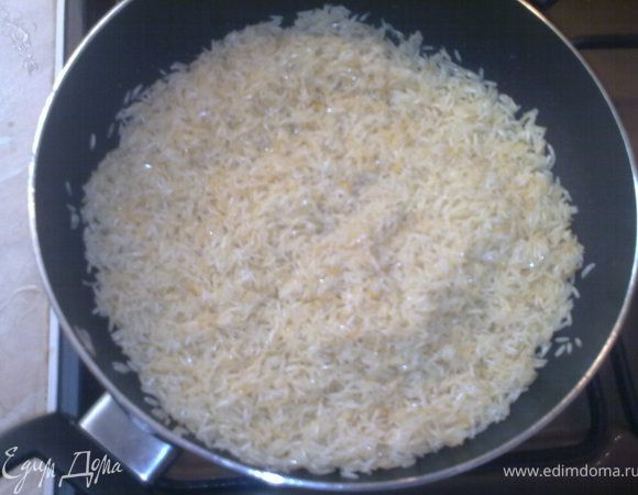 разогреть кастрюлю с маслом(у меня была,глубокая сковородка)выложить туда рис и хорошенько прожарить,перемешивая деревянной ложкой,пока не поменяется цвет риса,он должен быть светло- розового цвета