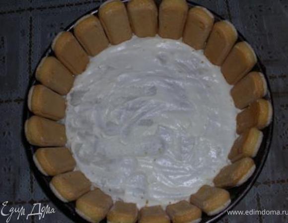 Разъемную форму выстелить пекарской бумагой и смазать немного кремом. Сделать бортик из печенья. 
