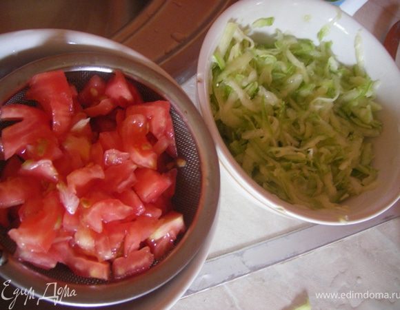 Кабачок трем на терке, солим, отжимаем, помидор очищаем от кожуры, мелко режем и даем стечь