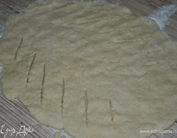Вымешайте со сметаной, пока тесто не станет однородным и не будет легко отделяться от стенок. Слегка обомните и раскатайте в тонкий пласт на посыпанной муке пергаментной бумаге.
Сделайте прорези в центре пласта под углом 45 гр. с интервалом в 2,5 см.