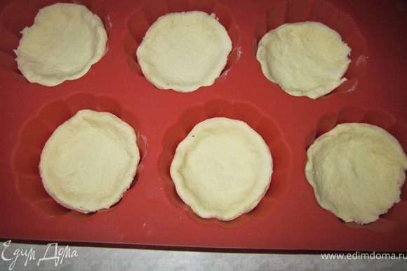 Тесто раскатать, вырезать формочкой круглые заготовка, по две заготовки на один пирожок. Выложить первый кружок в формочки для запекания.