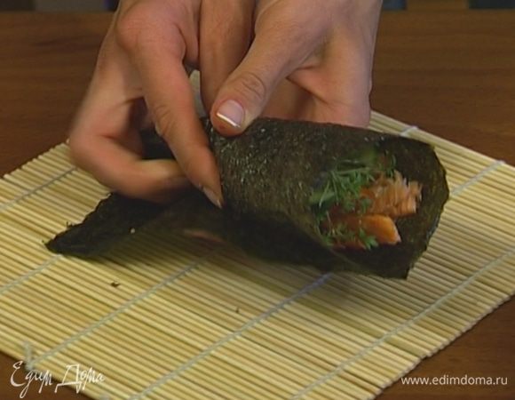 Присыпать кунжутным семенем, сверху выложить разобранное мясо семги и свернуть лист в кулечек.