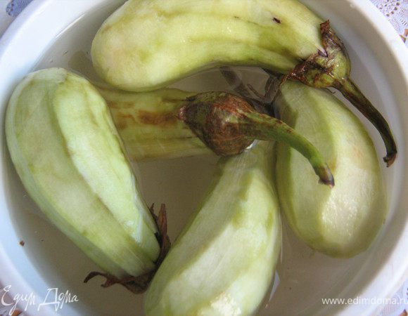 Баклажаны почистить,хвостики оставить,положить очищенные баклажаны в солёную воду на 15-20 минут.