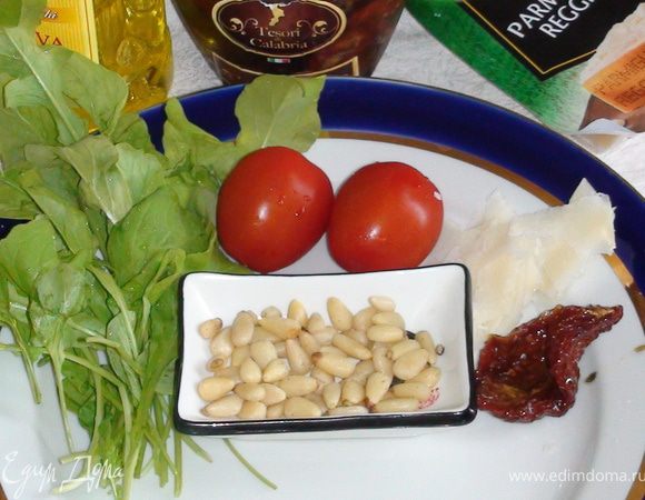 Руколу и помидорчики помыть, просушить; тонко нарезать пармезан. Подготовить кедровые орешки. Сушенный помидор порезать тонкими полосками.