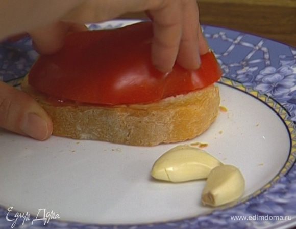 Натереть каждый тост чесноком, а затем половинкой помидора (в результате в руках должна остаться только кожица). 