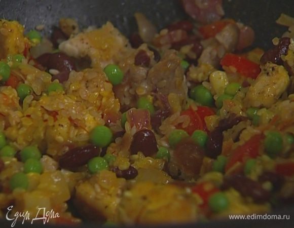 Добавить в сковороду отваренную фасоль, размороженный горошек, нарезанные колбаски, свинину, курицу, рис и размоченный шафран, влить 50 мл вина и 1 ст. ложку оливкового масла.