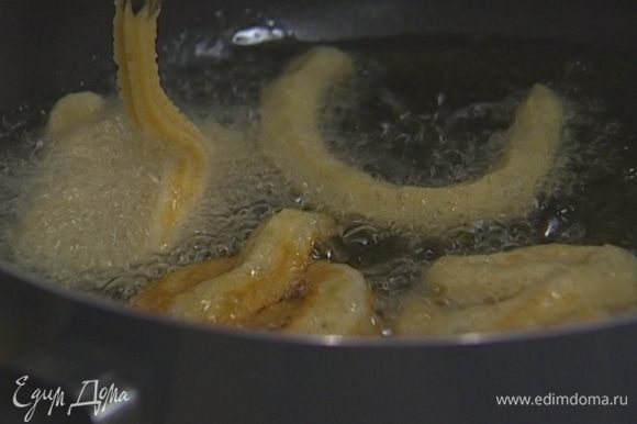 Разогреть в глубокой сковороде растительное масло, выдавливать на сковороду тесто полосками длиной 5–10 см, формируя кольца или спирали и обжаривать их до золотистого цвета. Не стоит готовить больше 3–4 полосок за раз!