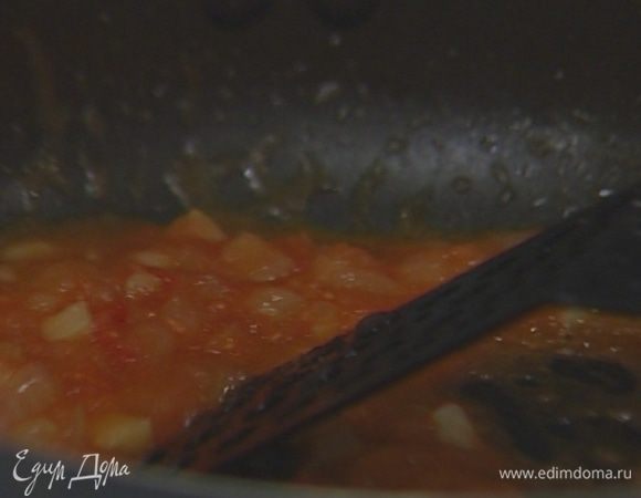 Один помидор натереть на терке, выложить в сковороду к луку и чесноку, всыпать по щепотке соли, свежемолотого черного перца и орегано. 