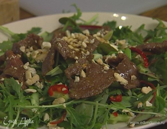 Листья салата вымыть, просушить и выложить на тарелку, присыпать огурцом, луком, кинзой и чили. Сверху разложить кусочки мяса, присыпать орехами и полить заправкой из вока.