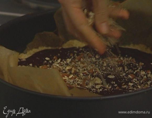 Вылить соус на пропеченное тесто, присыпать орехами и оставшимся тестом. 