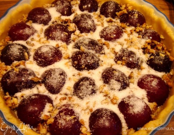 Сливы разрезать пополам и удалить косточки.Грецкие орехи крупно измельчить.2/3 теста раскатать на пергаменте по размеру формы + 4 см.Перевернуть на форму и аккуратно распределить тесто по краям и дну формы.Выложить сливы,засыпать их грецкими орехами и сахаром. 
