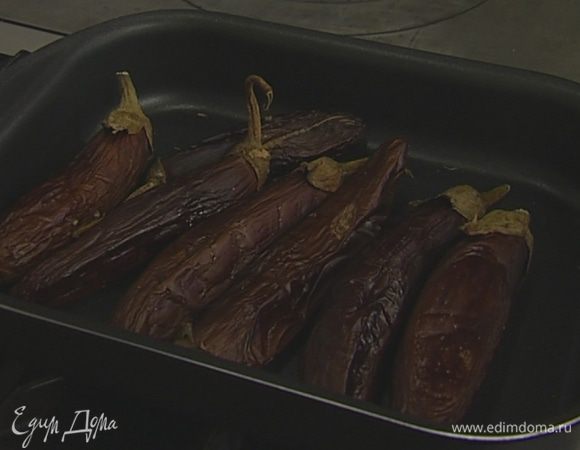 Каждый баклажан проткнуть вилкой в нескольких местах (чем больше будет дырочек, тем лучше). Уложить баклажаны на противень и запекать в разогретой духовке 40-60 минут, в зависимости их от размера. Запеченные баклажаны опустить в холодную подсоленную воду, очистить от кожицы и порубить на мелкие кусочки.