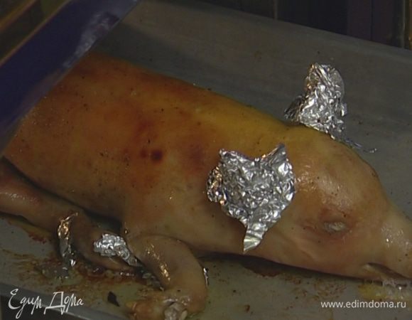 Запекать поросенка в разогретой духовке полтора часа, время от времени поливая выделяющимся соком, затем снять фольгу и запекать еще около получаса до готовности.