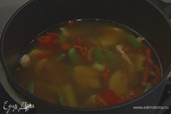 Добавить в суп замороженные овощи и варить несколько минут до готовности.