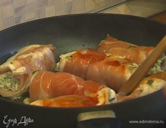 Обжаренные рулетики уложить в небольшую форму для выпечки, добавить оставшееся сливочное масло, полить вином и запекать в разогретой духовке 25–30 минут.