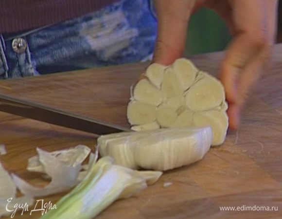 С чеснока снять верхнюю грубую кожицу и разрезать головку поперек пополам.