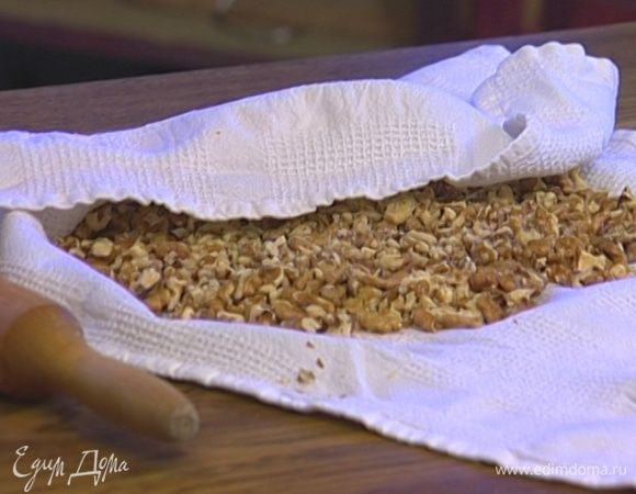 Орехи завернуть в полотенце и измельчить скалкой, так чтобы получились кусочки разных размеров. 