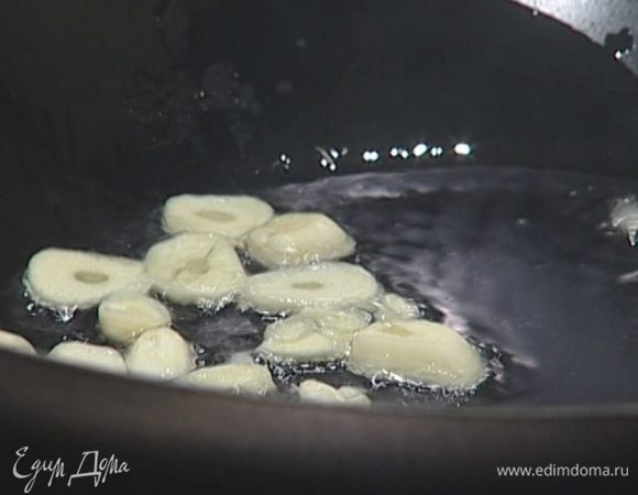 В сковороде вок разогреть кунжутное масло и слегка обжарить чеснок.