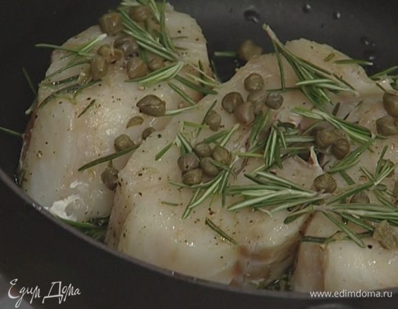 В огнеупорную посуду или в глубокий противень выложить веточки розмарина (1 веточку оставить), сверху положить рыбу, присыпать каперсами и листьями с оставшейся веточки розмарина.