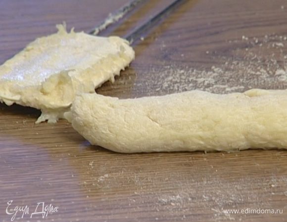 Остальную муку высыпать на рабочую поверхность, выложить тесто и сформировать из него колбаску диаметром 2–3 см. 
