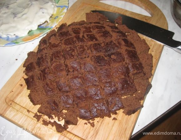 Разрежьте бисквит на 2 части. Основа должна быть примерно 1,5 см высотой. Остальное нарежьте кубиками.