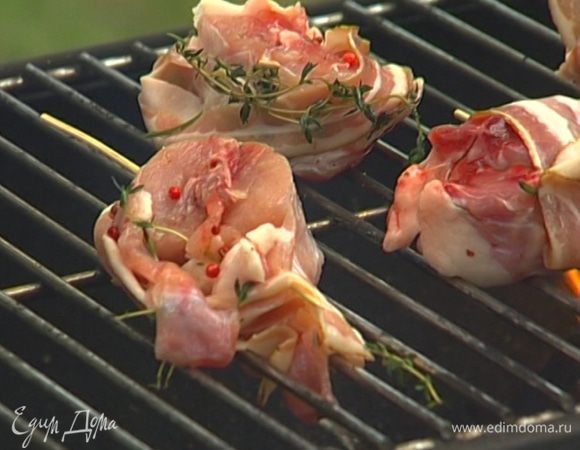 Обернуть каждый кусочек кролика беконом, проткнуть деревянной палочкой и обжарить на гриле до золотистой корочки. Подавать с дольками лимона.