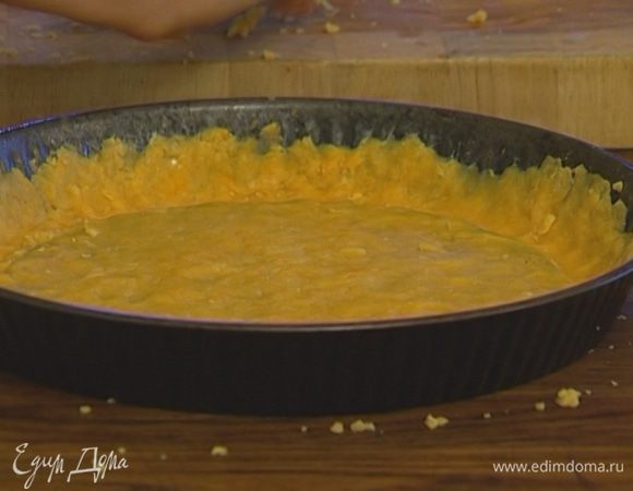 Форму для выпечки смазать оставшимся сливочным маслом. Тесто натереть на крупной терке прямо в форму и, прижимая пальцами, распределить его по всей поверхности, сделать бортики. 