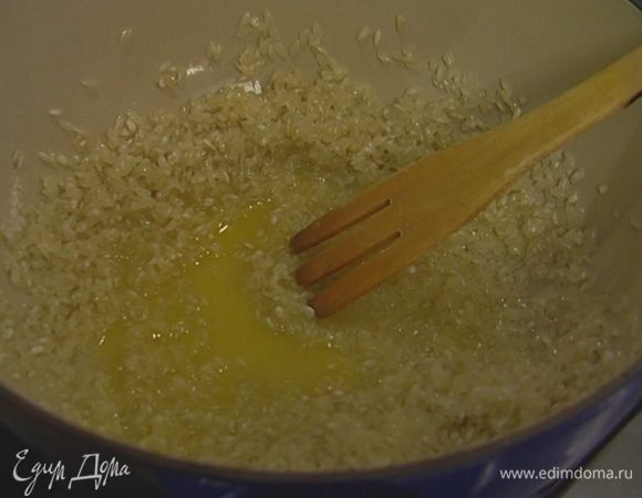 Растопить в глубокой тяжелой кастрюле сливочное масло, всыпать рис, перемешать и прогревать на небольшом огне 2–3 минуты, чтобы рис пропитался маслом.