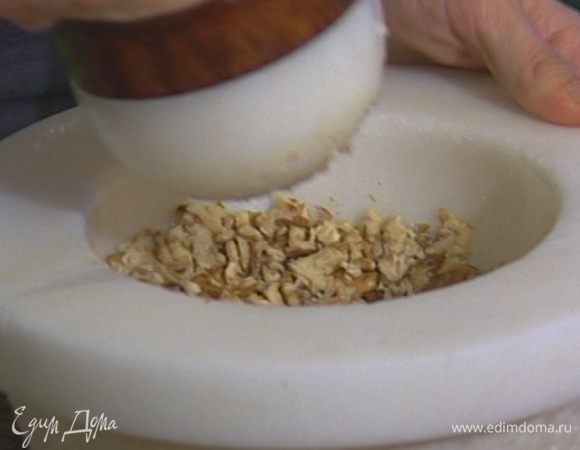 Грецкие орехи растереть в ступке с чесноком и щепоткой соли в однородную мелкую крошку. 