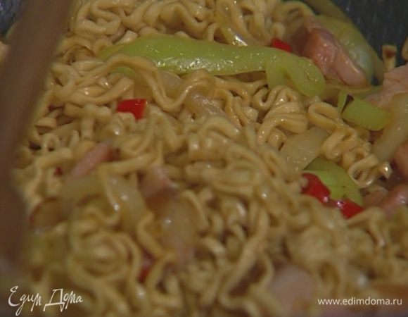 Когда лук слегка зазолотится, добавить грудинку, нарезанный перец и вермишель, влить соевый соус, овощной бульон, портвейн, уксус и, непрерывно помешивая, готовить все 2–3 минуты.