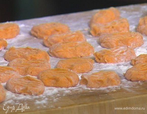 С помощью чайной ложки формировать в ладони из теста ньокки, вилкой придавливать бока и укладывать на поверхность, присыпанную мукой.