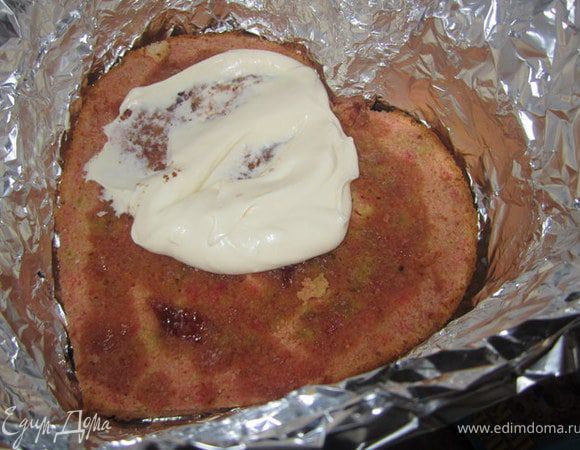 Подготовить разъемную форму, в которой выпекался бисквит.
Бока закрыть пергаментной бумагой или фольгой.
Выложить на низ самый ровный корж.
Покрыть слоем крема.