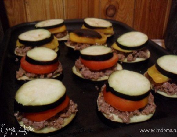 На противень слегка смазанный маслом разложить баклажаны, сверху на каждый кружок лепешечку обжаренного фарша, поверх фарша помидор, сверху еще кружок баклажана.