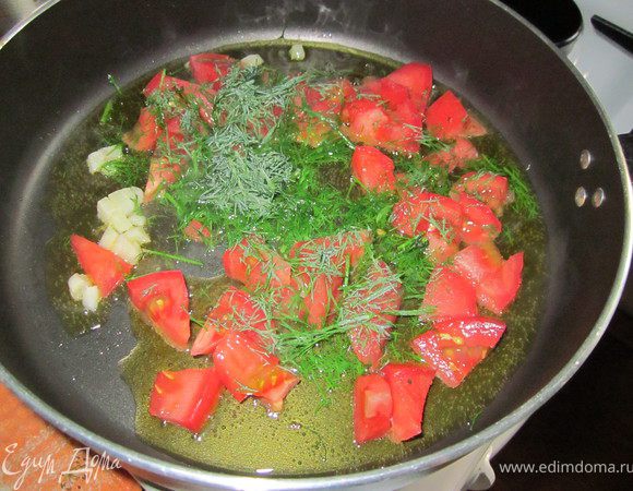 Чеснок мелко порубить, обжарить. Томат очистить от кожуры, порезать на небольшие кусочки, добавить в сковороду с чесноком. Прогреть 3-4 минуты. Добавить зелень.