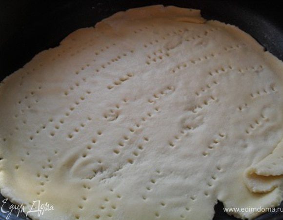 Сковороду смазать маслом, уложить на нее корж, сделать на нем проколы вилкой.