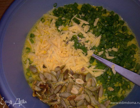 Добавить измельченный зеленый лук, половину натертого сыра и обжаренные без масла тыквенные семечки