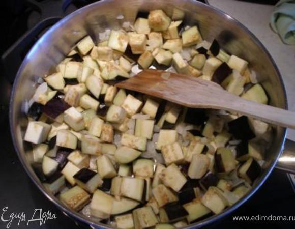 Баклажаны нарезать кубиами и добавить к луку. Жарить до полуготовности. 