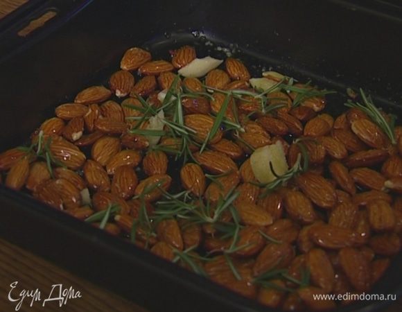 Миндаль высыпать на противень, полить оставшимся оливковым маслом, присыпать чесноком, сахаром, сычуаньским перцем, щепоткой крупной соли и оставшимися листьями розмарина. Отправить в духовку на 20–30 минут.