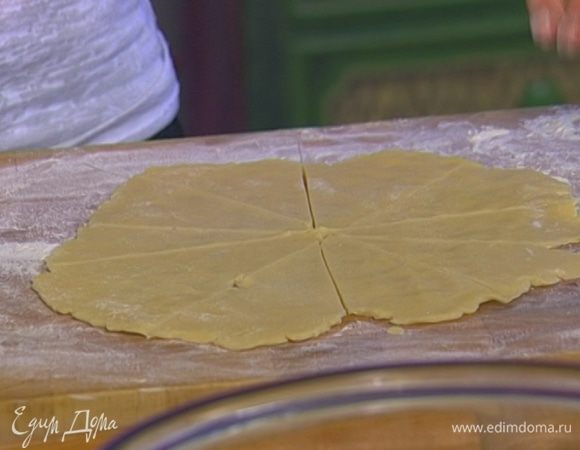 На присыпанной мукой поверхности раскатать каждую часть теста так, чтобы получился круглый пласт диаметром 25–30 см, а затем разрезать его на треугольники.