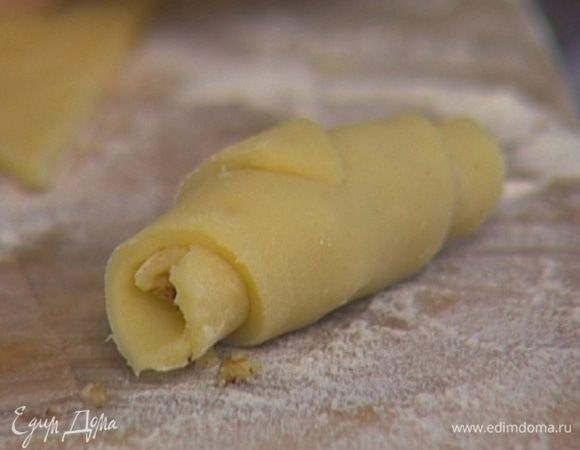 На широкую часть каждого треугольника выложить немного ореховой начинки и свернуть в трубочку.