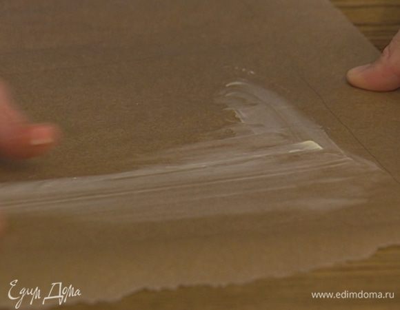 Смазать сливочным маслом два листа бумаги для выпечки одинакового размера. 
